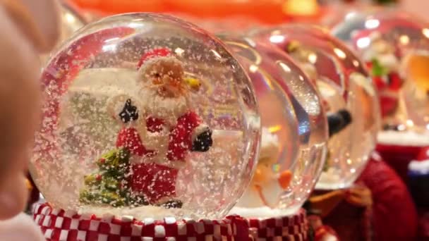 París, Francia - 11 de diciembre de 2019: Raw of small snow globes Santa Claus sold in Christmas market, Paris — Vídeo de stock