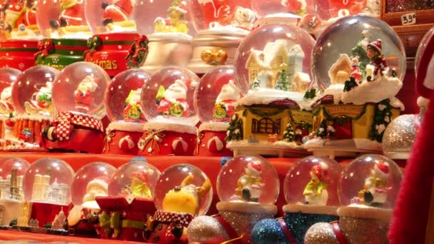 Paris, Frankrike - 11 december 2019: Raw of small snow gloes Santa Claus såld på julmarknaden — Stockvideo