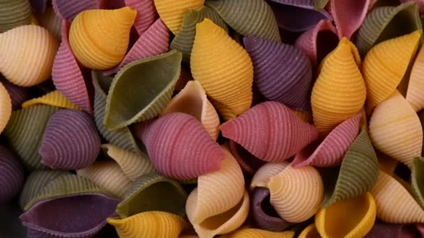 Pile of multicolored raw italian pasta rotating — Stockvideo