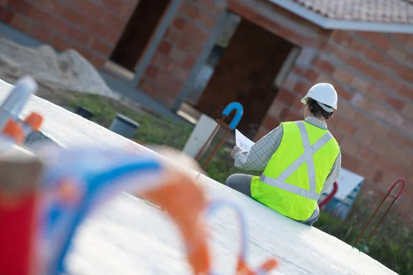 Professionell ingenjör arkitekt arbetare med skyddshjälm och ritningar papper på hus byggnad byggarbetsplats bakgrund — Stockfoto