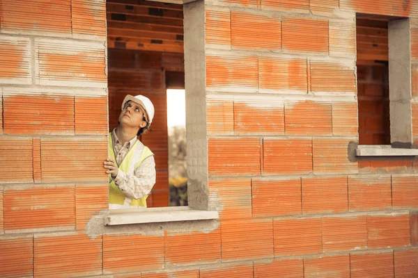 Ingeniero profesional arquitecto trabajador con casco protector en el edificio de la casa sitio de construcción de fondo —  Fotos de Stock