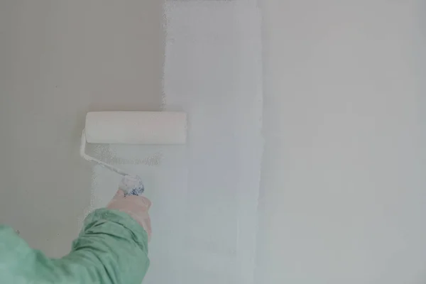 Роликове фарбування білої стіни, стеля з білою фарбою — стокове фото
