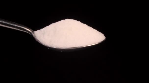 Закрыть белый сахар Капание из нержавеющей стали на черном фоне — стоковое видео