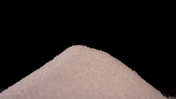 Hand uses spoon to pick sugar out of a heap black background — 图库视频影像