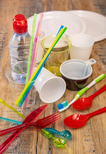Щоденні пластикові відходи, різні пластикові посуд, захист навколишнього середовища на фоні деревини Ліцензійні Стокові Зображення