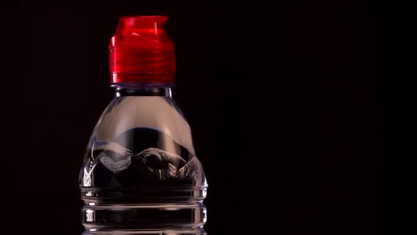 Water bottle on turntable on black background — 图库视频影像