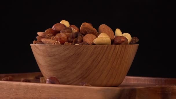 View of wood bowl full of variety of nuts on black background — 비디오