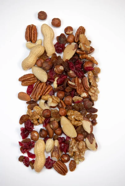 Mixed nuts and dried fruits in wooden bowl on white background, copy space