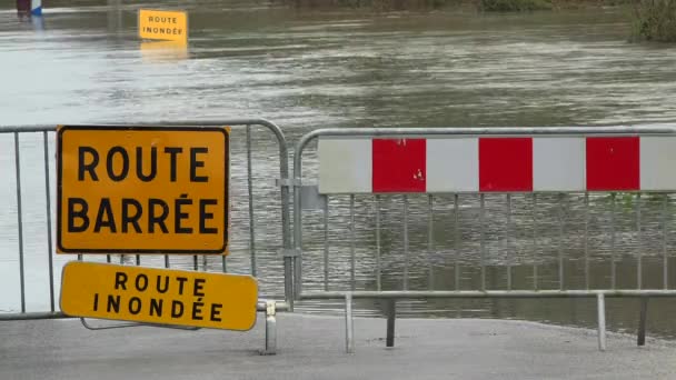 Agua sobre la carretera, carretera inundada por el desbordamiento de un río y señal de peligro de la carretera — Vídeos de Stock