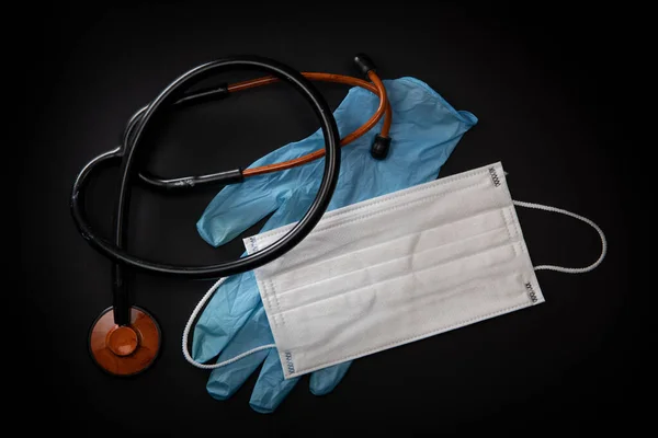 Equipo médico de protección durante una epidemia de virus, máscara quirúrgica, gafas, estetoscopio y guantes médicos — Foto de Stock