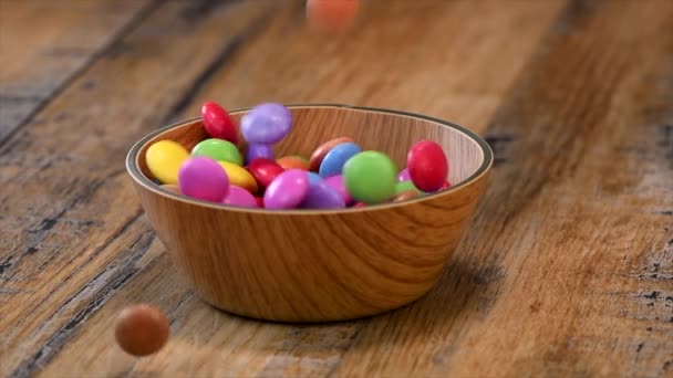 Zeitlupe, bunte Bonbons in einem Holzschälchen-Etui isoliert auf Holzhintergrund — Stockvideo