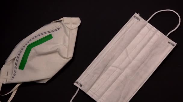 Защитное медицинское оборудование во время вирусной эпидемии, хирургическая маска на черном фоне — стоковое видео