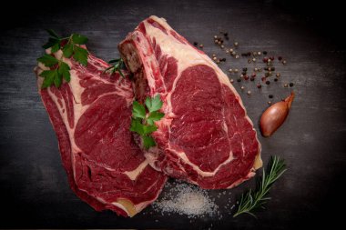 Tahtadaki çiğ T-Bone bifteği ızgaraya hazır. 