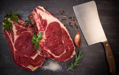 Tahtadaki çiğ T-Bone bifteği ızgaraya hazır. 