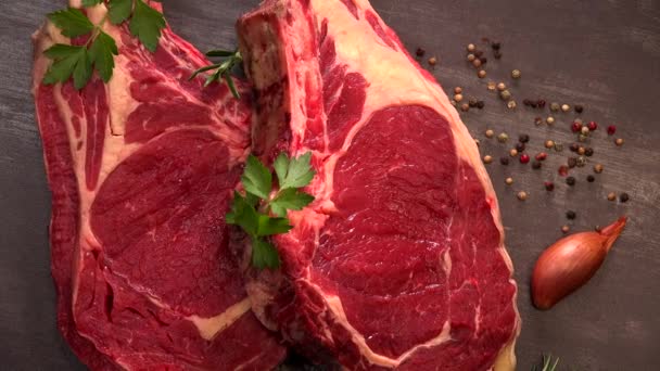 Rauwe T Bone steak op houten plank bereid om te grillen op draaitafel — Stockvideo