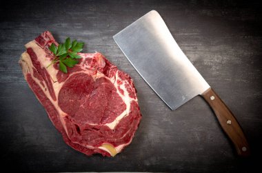 Tahtadaki çiğ T-Bone bifteği ızgaraya hazır. 
