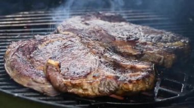 Kömür ve alevlerle ızgarada büyük sulu pirzola bifteği.