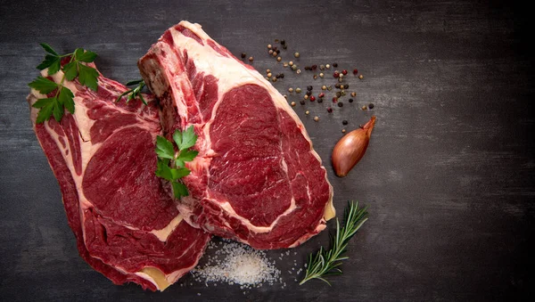 Bife de osso T cru em tábua de madeira preparada para grelhar — Fotografia de Stock