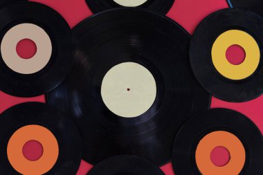 Kırmızı arkaplanda fotokopi alanı olan vinil plaklar ve vinil plaklar. 