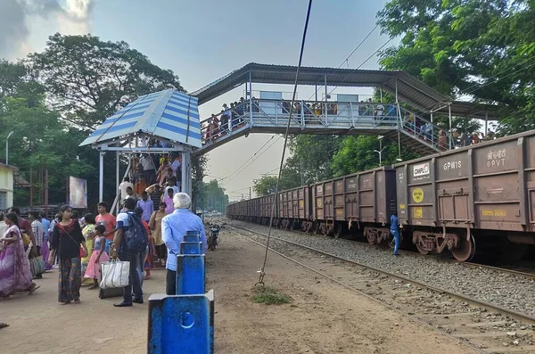 Des gens traversent à pied le pont de la gare de Jhargram, au Bengale occidental, en Inde. Vue large du train . — Photo