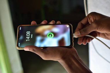 Tahta masada şarj aleti var. mobil şarj konsepti. Cep telefonu çılgınlığı kavramı. cep telefonu şarjı% 99..