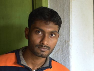 Beyaz arka plan üzerinde izole mutluluğu ile kameraya bakarak gülümseyen genç adam