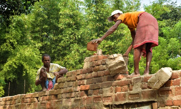 インド・ジャルグラム11月：インド人の男がレンガの壁をハンマーで壊し、家を建て直し、修理する. — ストック写真