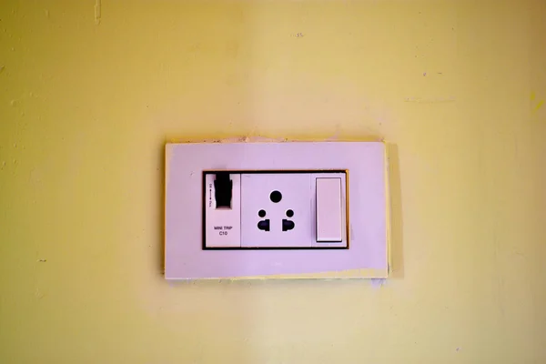 Dimmer switch and light switch on switchboard. Beautiful painted room wall with a switch board.