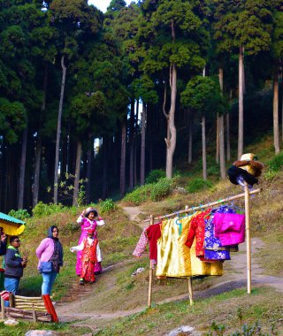Lamahata, Darjeeling, Hindistan - 26 Aralık 2019: Hindistan 'da geleneksel bir nepal ve bhutan elbise kiralama dükkanından renkli koleksiyondan Kimono' yu seçen kadın.