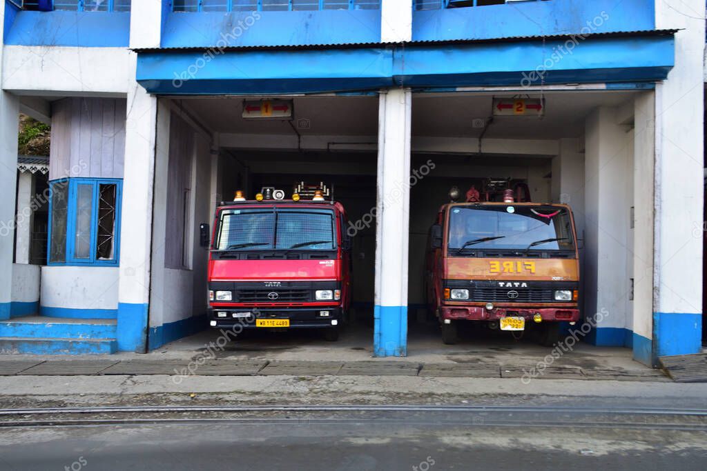 Ghoom, West Bengal, India- December 27, 2019: Red and white fire trucks ready for action on a high fire danger day at Ghoom Fire Brigade station, Darjeeling.