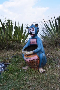 Beyaz bir tavşan yeşil bitkilerle, ağaçlarla, arka planda çimlerle bahçeyi kapladı.