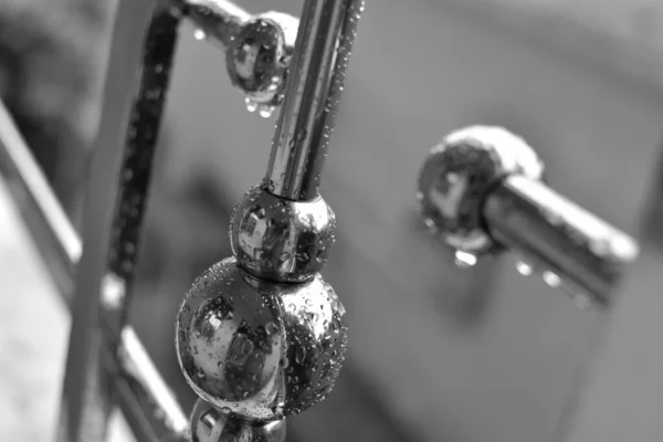 雨天从金属棒上滴下的水晶状雨滴 钢栏杆的黑白抽象画框 — 图库照片