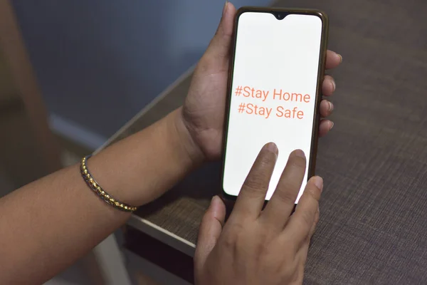 Stay home save lives for self quarantine times. Hand holding mobile smart phone. Coronavirus or Covid-19 social media campaign concept, stay at home, social distancing for protect corona virus concept. selective focus