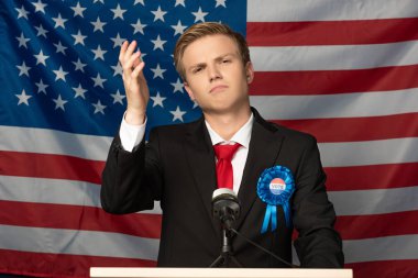 displeased man on tribune on american flag background