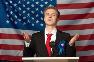 emotional man on tribune during speech on american flag background