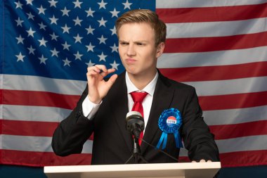 displeased man on tribune on american flag background