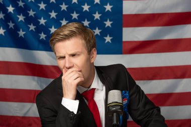 pensive man on tribune on american flag background clipart
