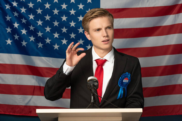  emotional man on tribune during speech on american flag background