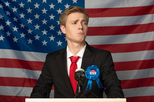 concentrated man on tribune on american flag background