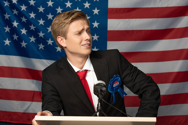 confident man on tribune on american flag background