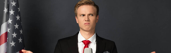 dissatisfied emotional man with american flag on black background