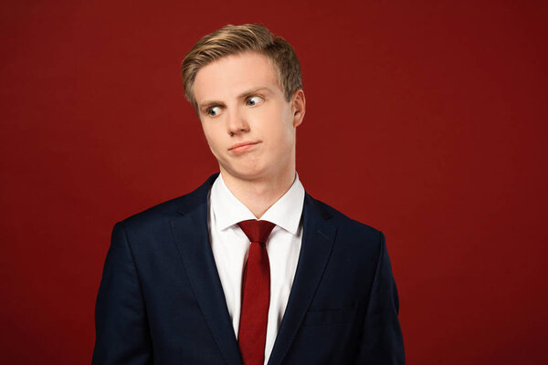 confused man looking away on red background