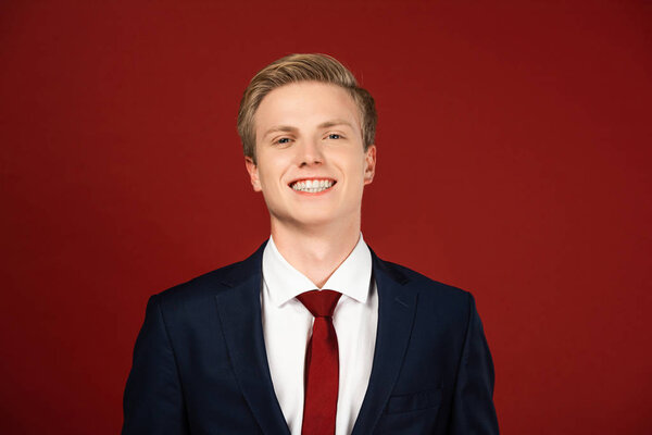 smiling man in suit on red background