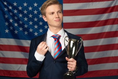 Amerikan bayrağında altın kadeh tutan adam.