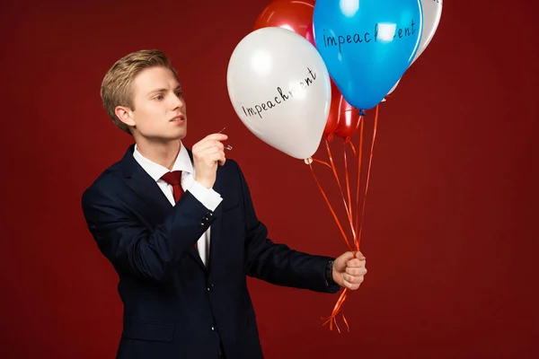 Man Bursting Balloons Impeachment Lettering Red Background — Stock Photo, Image