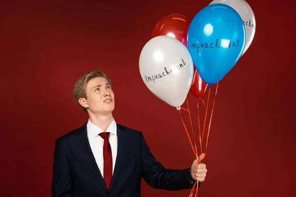 Emotional Man Holding Balloons Impeachment Lettering Red Background — Stock Photo, Image