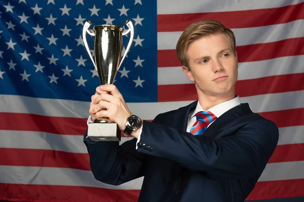 Muž Drží Zlatý Pohár Pozadí Americké Vlajky — Stock fotografie