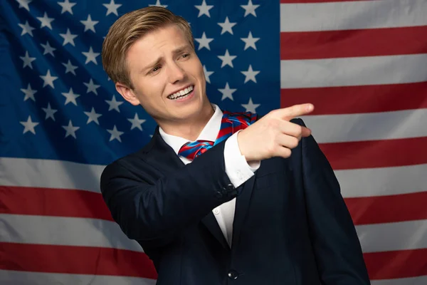 Sorrindo Homem Apontando Com Dedo Afastado Fundo Bandeira Americana — Fotografia de Stock