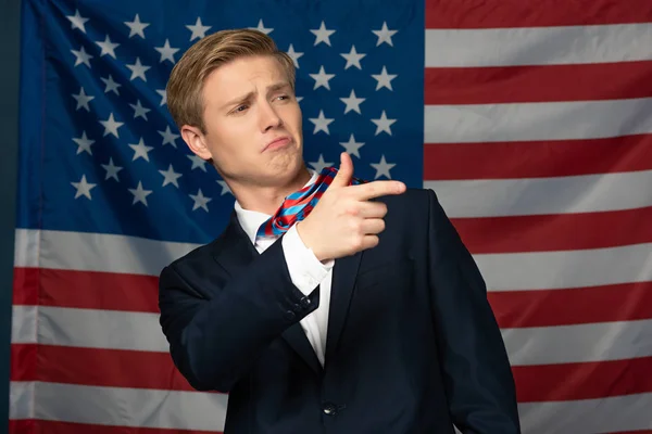 man pointing with finger away on american flag background