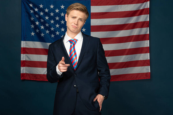 man pointing with finger at camera on american flag background